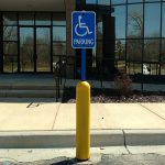 Yellow Bollard Sign System used for handicap accessible parking spots