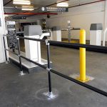 Black Pipe and Plastic Handrail used for protection around parking garage entrance