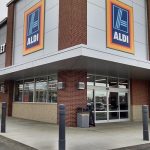 Black 6-inch Architectural Decorative Bollard Covers used for storefront protection at Aldi