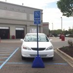 Blue plastic portable sign bases used as handicap accessible parking signage